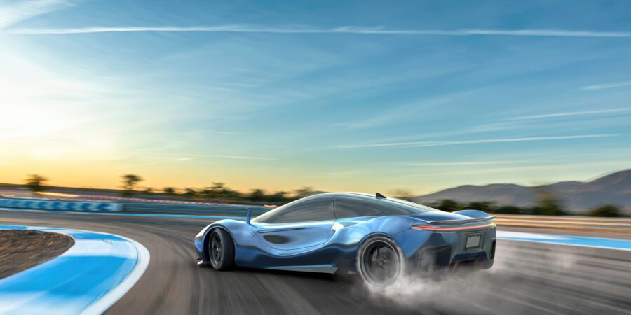 A blue electric sports car moving at high speed around the corner of a racetrack. The vehicle is drifting around the corner, with smoke coming from its spinning rear tires. The racetrack is in a remote location with distant hills. It is sunset/sunrise under a blue sky.